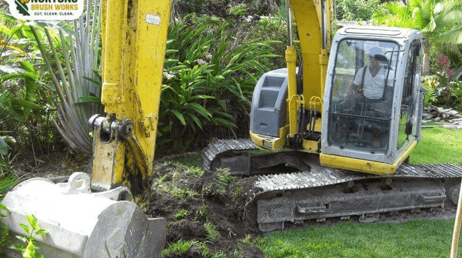 Commercial high-horsepower stump grinder pulverizing large tree stump below grade